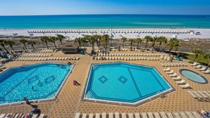 Resort com duas piscinas grandes, praia e posto de salva-vidas.