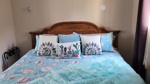 Cama com colcha floral azul e manta azul fofa.