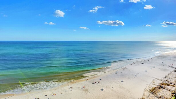 A beach with clear blue water, sandy shore, and a few people. - Escapes to the Shores 1702 by Liquid Life (Orange Beach)