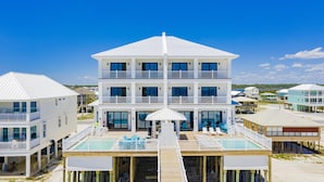 A multi-story beachfront hotel with a pool, balconies, and a view of the ocean. - Seaside East and West ( 2 Properties - 24 Bedrooms) (Gulf Shores)