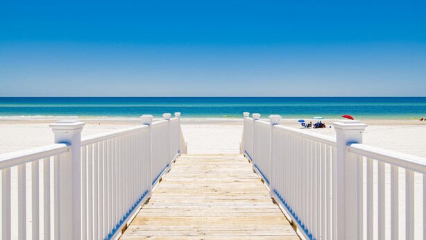 A wooden boardwalk leading to a beach with white railings and a clear blue sky. - Seaside East and West ( 2 Properties - 24 Bedrooms) (Gulf Shores)