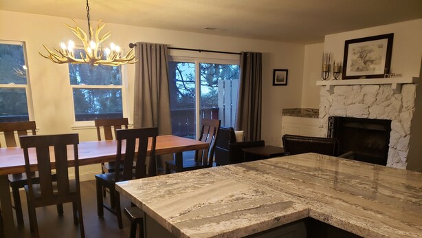 A modern kitchen with a large island, dark cabinetry, and a stone fireplace. - NORTH LAKE TAHOE VACATION RENTAL WITH SKI AND MOUNTAIN VIEWS, HIKE & BIKE TRAILS (Incline Village)
