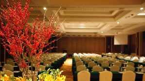 A banquet hall with rows of tables, chairs, and a floral centerpiece. - Kingdom Hotel Yiwu (Jinhua)