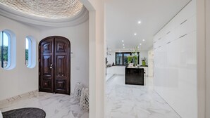 A modern interior with a marble floor, a dark wooden door, and a kitchen area with a black countertop. - Seafront View next to the famous “Benagil Caves” (Lagoa)