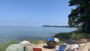 Ein Strand mit zwei Liegen und einer Feuerstelle.