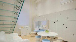 A modern bathroom with a glass shower enclosure, a round white table with stools, and a mirrored cabinet. - Cosy apartment for 7 people with WIFI, A/C, TV and patio (Viareggio)