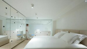 A modern bedroom with a large bed, a glass-enclosed wardrobe, and a bathroom with a toilet and sink. - Cosy apartment for 7 people with WIFI, A/C, TV and patio (Viareggio)