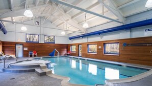 An indoor swimming pool with a wooden wall, a hot tub, and a pool ladder. - Spacious 3 Level 3BR+3Bath Townhouse w/Fireplace (Dover)