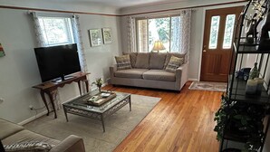 A living room with a sofa, coffee table, TV, and a bookshelf.