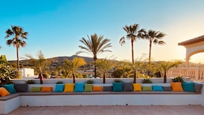 A rooftop terrace with a seating area, wooden loungers, and palm trees. - Villa - Sleeps 7 - Pool - Parking (Javea)