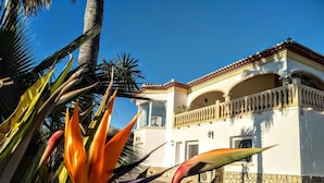 A building with a white facade, red-tiled roof, and a balcony with a balustrade. - Villa - Sleeps 7 - Pool - Parking (Javea)