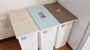 Drei Aufbewahrungsboxen mit Etiketten auf einem Holzboden vor einer Wand.