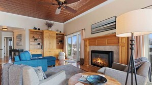 Un salón espacioso con chimenea, un sofá azul, un sofá gris y una mesa de centro de madera.