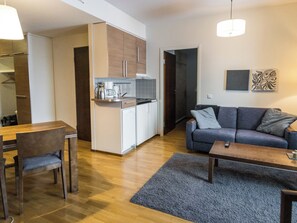 A modern apartment with a dining area, kitchenette, living room, and a gray sofa. - Ylläs chalets 2101 by Interhome (Ylläsjärvi)