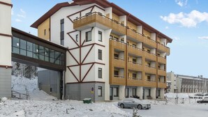 Ein mehrstöckiges Gebäude mit modernem Design, das Balkone und große Fenster kombiniert.
