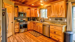 A kitchen with wooden cabinets, stainless steel appliances, and a granite countertop.