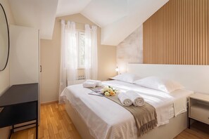 A hotel room with a bed, a bedside table, a desk, and a window with curtains. - Pool Villa Vese /w Panoramic Sea View, Trogir - Vinišće, Croatia (Trogir - Vinišće)