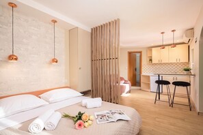 Ein modernes Hotelzimmer mit einem Bett, einer kleinen Küchenzeile und einem Badezimmer.
