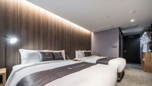 A hotel room with two beds, a wooden panel wall, a small desk, and a wardrobe. - Layers Hotel Busan Hadan (Busan)