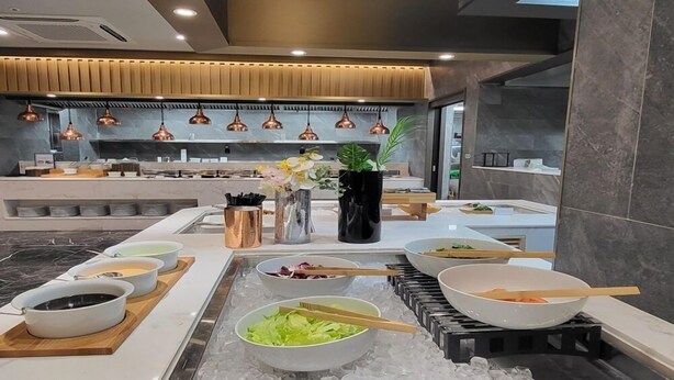 A modern kitchen with a central island, copper pendant lights, and a variety of bowls and utensils. - Layers Hotel Busan Hadan (Busan)