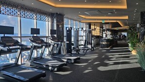 A modern gym with treadmills, weight machines, and a view of the city. - Layers Hotel Busan Hadan (Busan)
