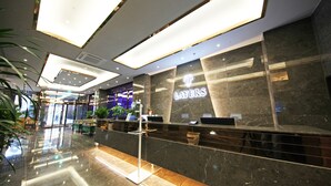 A modern hotel reception area with a marble counter, a sign reading "The Layers," and a glass partition. - Layers Hotel Busan Hadan (Busan)