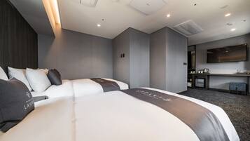 A modern hotel room with a large bed, a desk, and a flat-screen TV.
