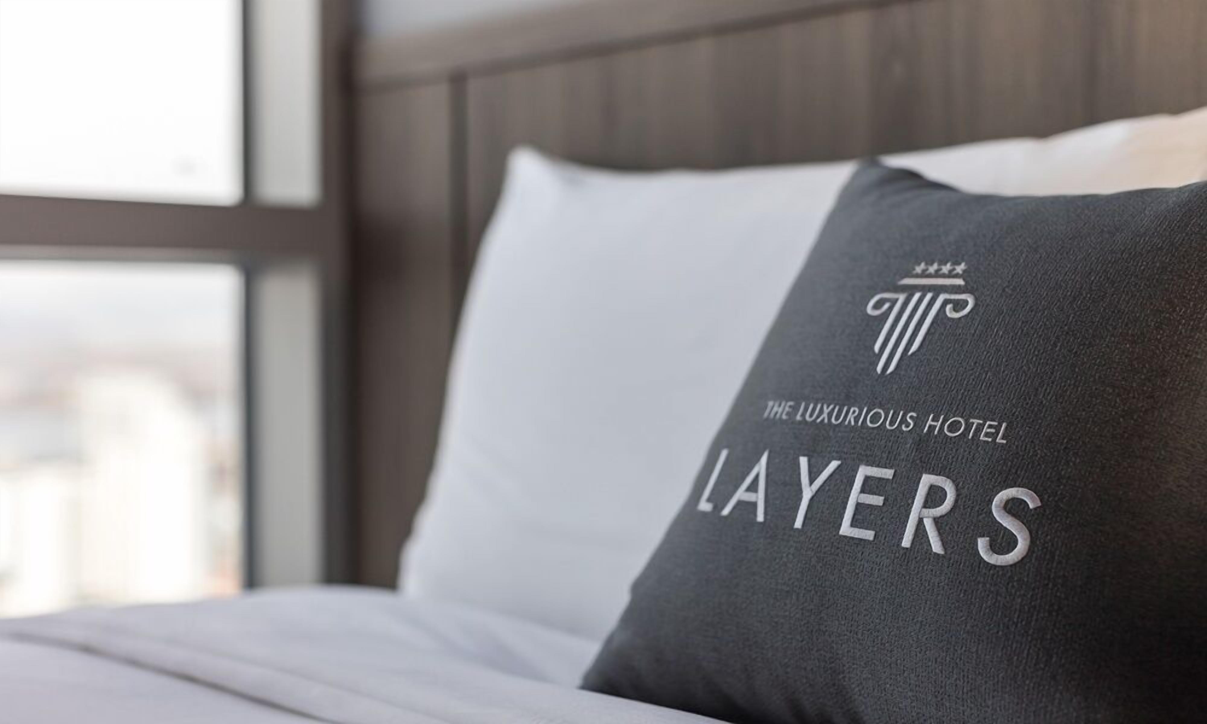A hotel pillow with the text "The Luxurious Hotel Layers" and a logo.
