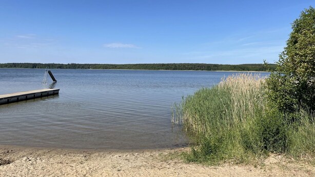 A calm lake with a wooden dock extending into the water. - Cosy apartment in villa for 6 people with WIFI, TV and terrace (Userin)