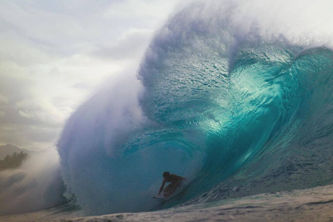 A surfer riding a large wave.