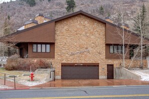 A stone building with a brown roof and a garage door labeled "2700". - Experience Comfort: Luxury Condo & Design, Wi-Fi, Free Shuttle & Great Location! (Park City)
