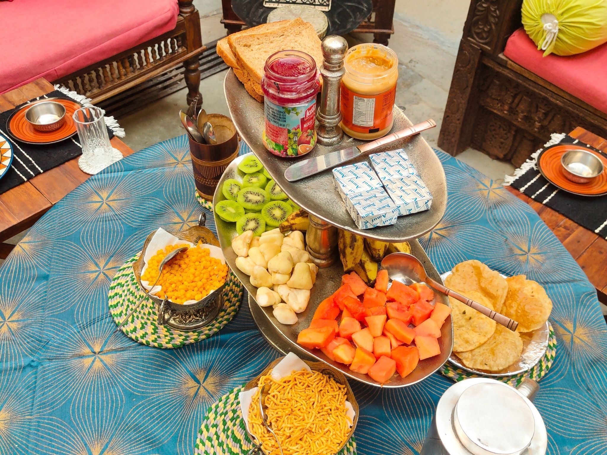 A table with various food items and condiments, including sliced fruits, nuts, and snacks.