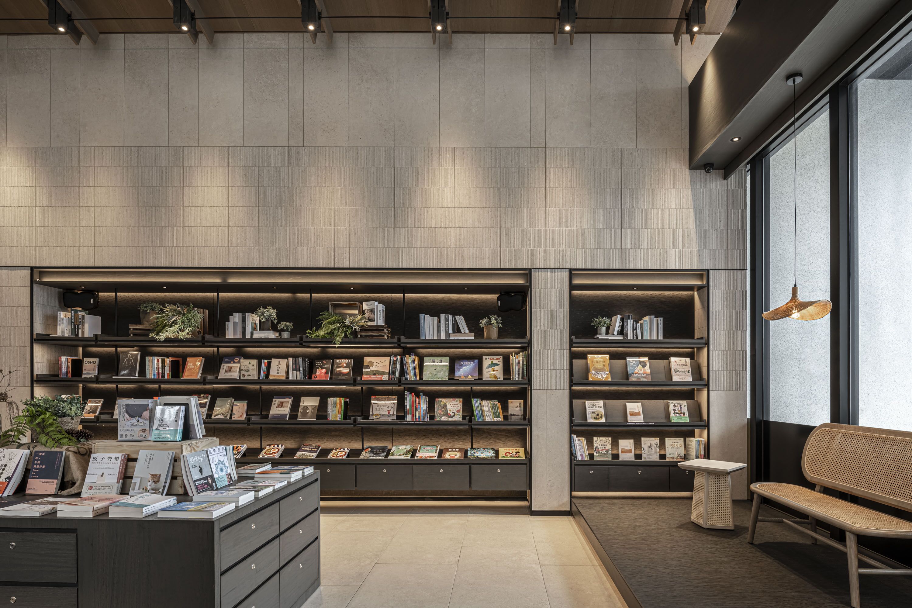 Une bibliothèque moderne avec des étagères, un banc et une petite table.