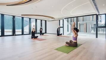A spacious yoga studio with large windows and a modern interior.