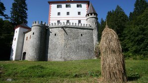 A castle with a stone wall, a tower, and a haystack in the foreground. - Mržek House with Sauna (Bloke)