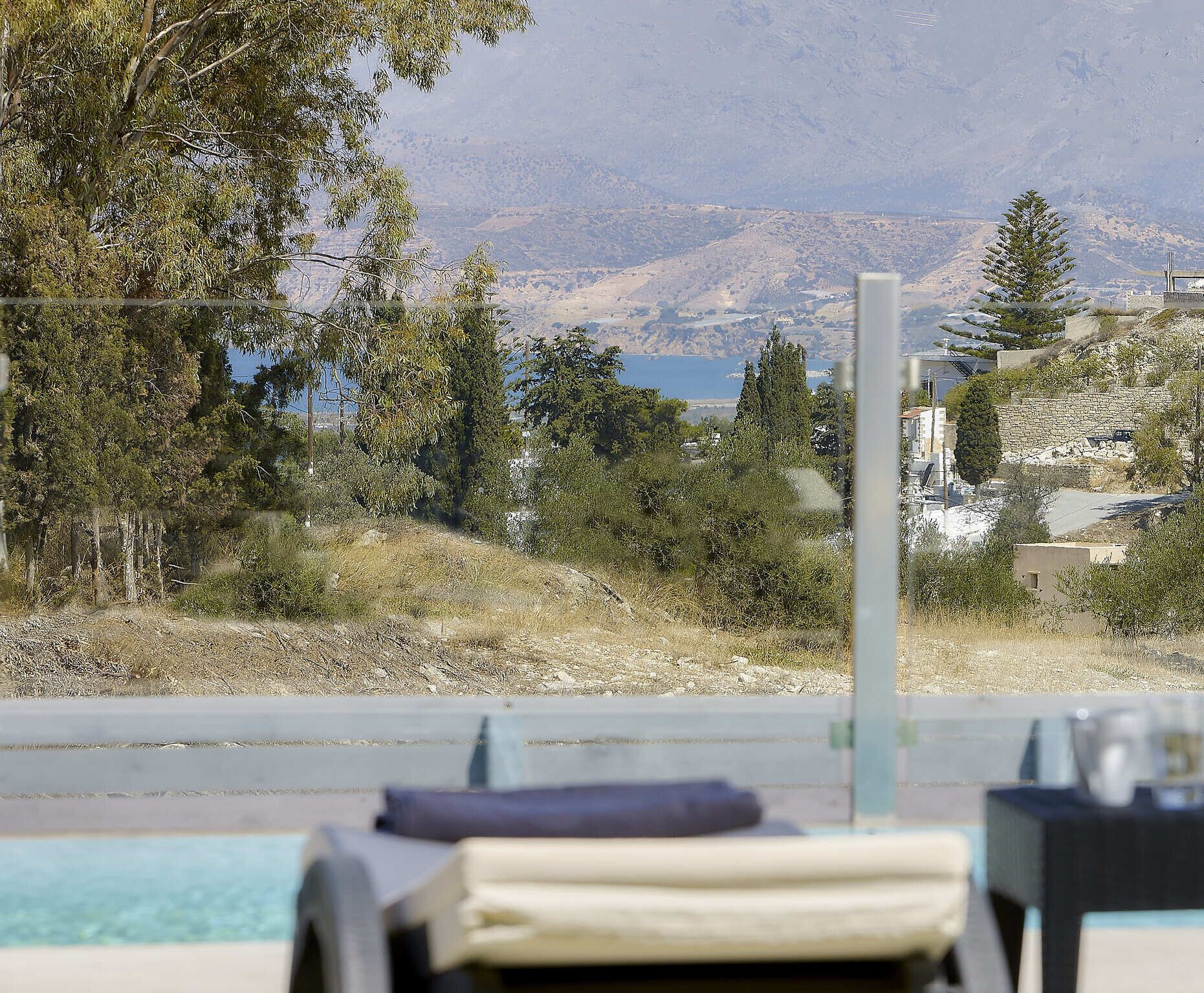 A poolside view with lounge chairs and a scenic mountain backdrop.