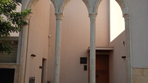 A building with a central courtyard, stone columns, and a wooden door. - Exclusive duplex near Jaffa fishermen port and old city, Family (Tel Aviv)