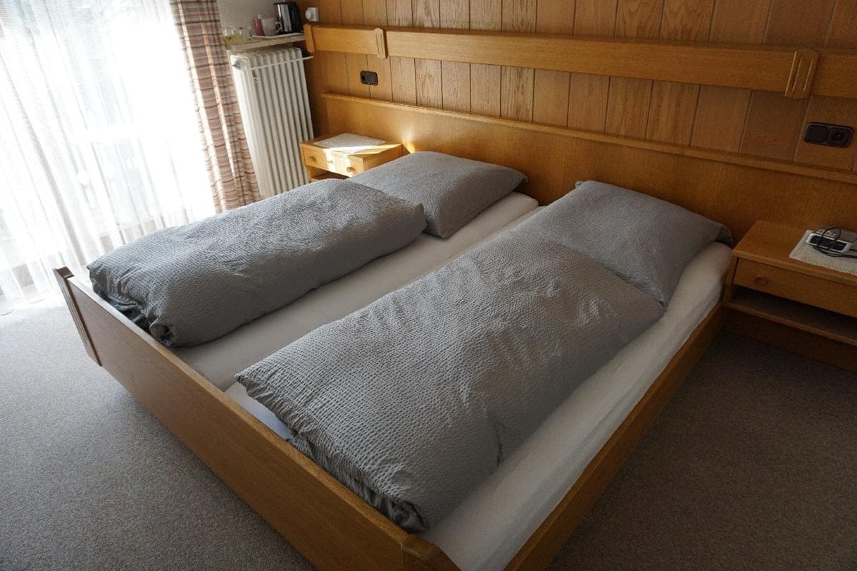 A double bed with a wooden headboard and two bedside tables.
