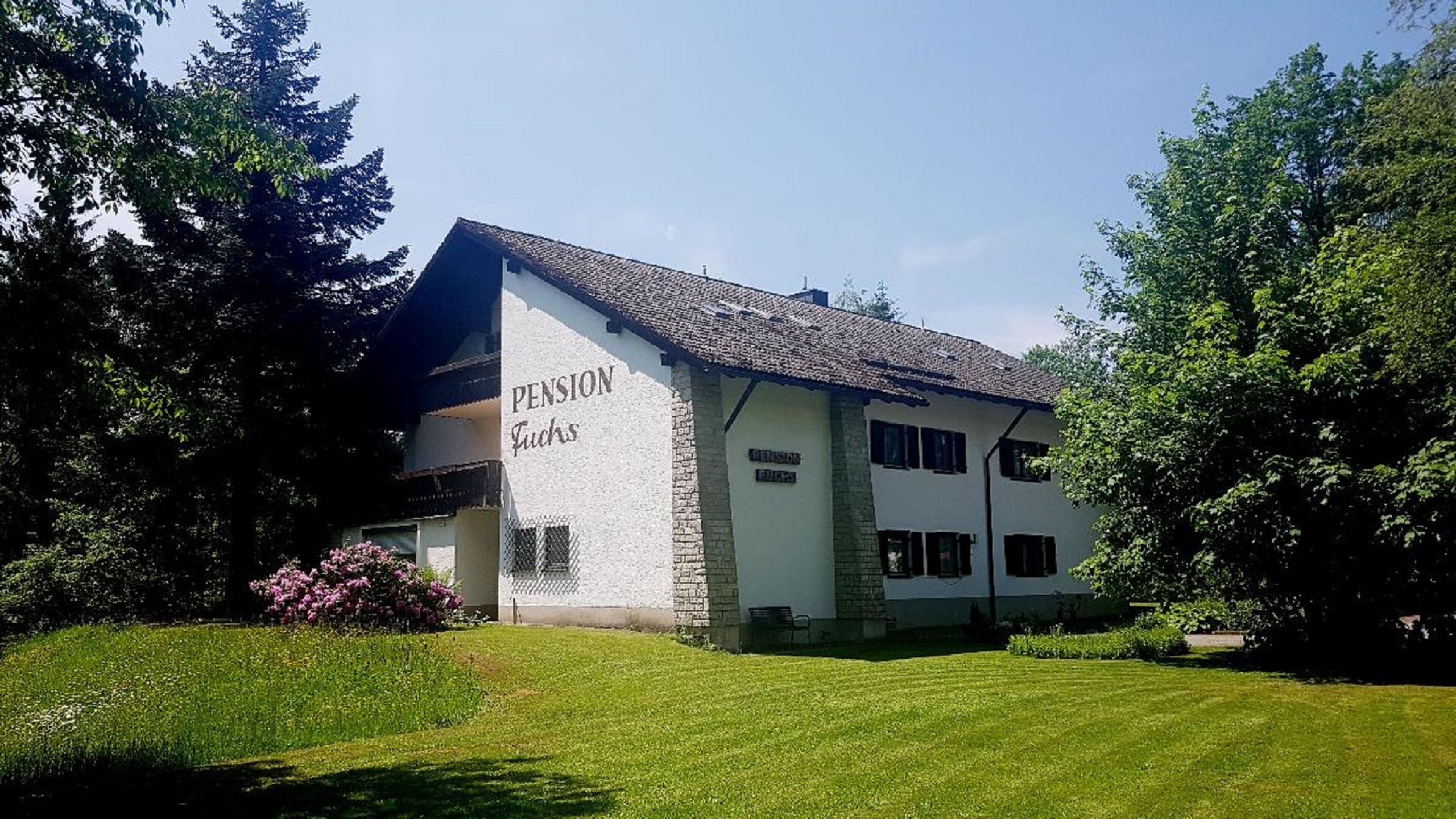 A two-story building with a sign reading "Pension Lucks."