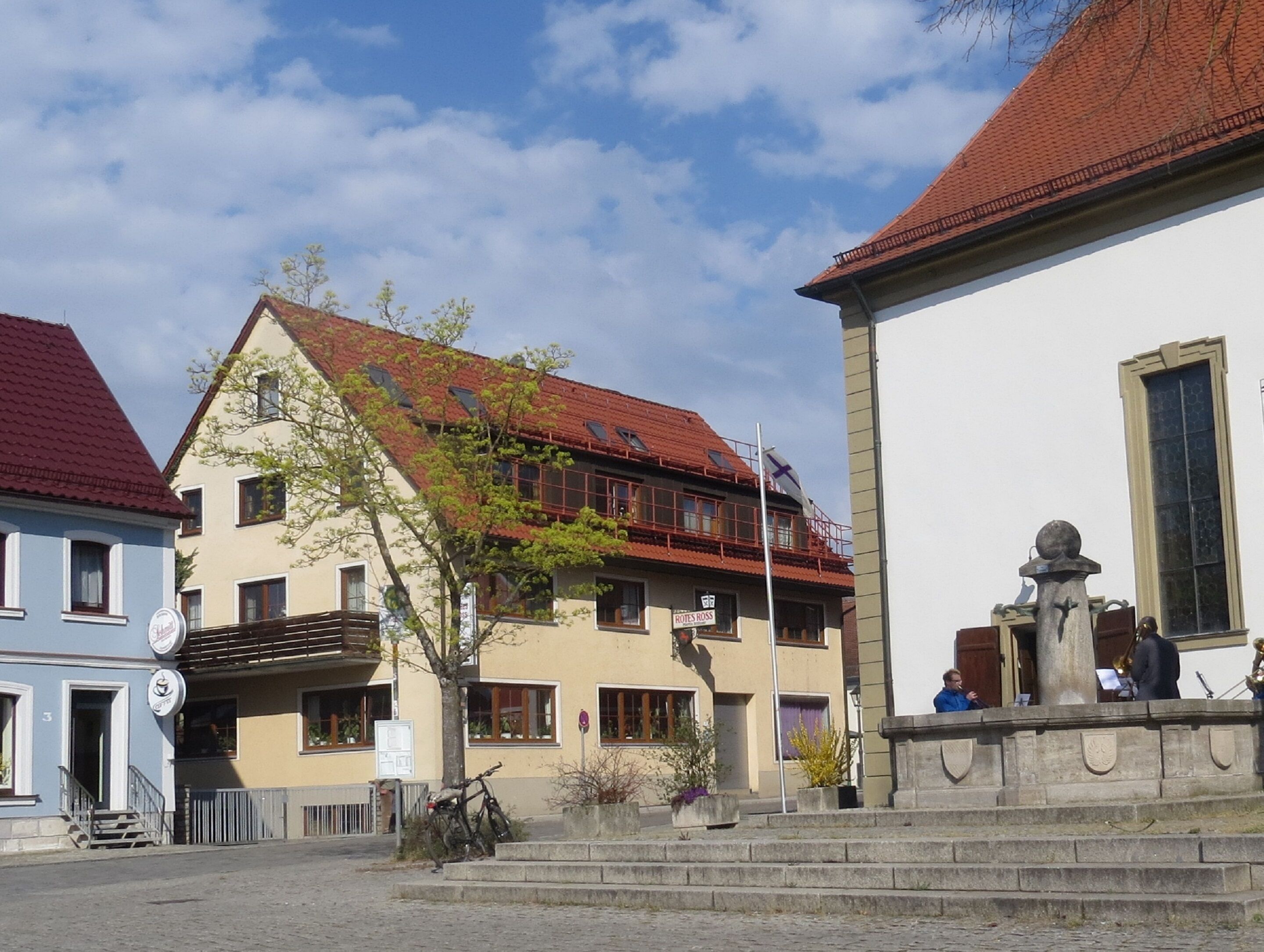 A building with a red roof and a sign that reads "ROTES ROSS".