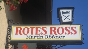 A sign for Rotes Ross, Martin Rönner, with a horse emblem and a clock. - Rotes Ross Burghaslach (Burghaslach)