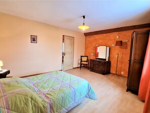 Cozy retreat with a bed, dresser, chair, and wardrobe, perfect for a comfortable stay.