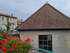 Simple, single-story home with a steeply pitched roof and a small window.