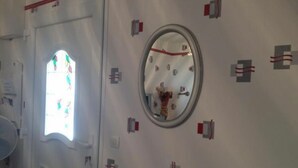 Une pièce avec une grande fenêtre, un miroir et une porte.