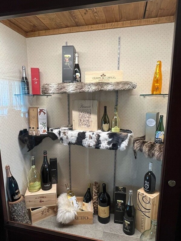 A wine display with various bottles and boxes, including brands like 'GILLESPIE' and 'ANDROLA.' - Hotel du Col (Sestriere)