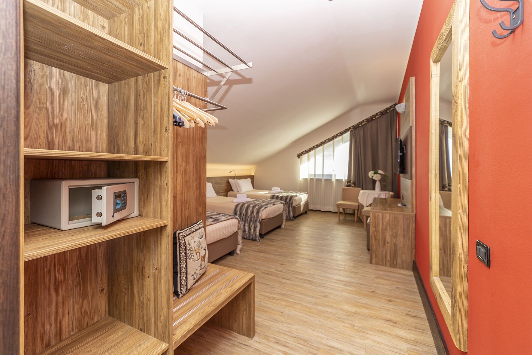 Una habitación moderna y compacta con cama tipo altillo, microondas integrado y estantería de madera.