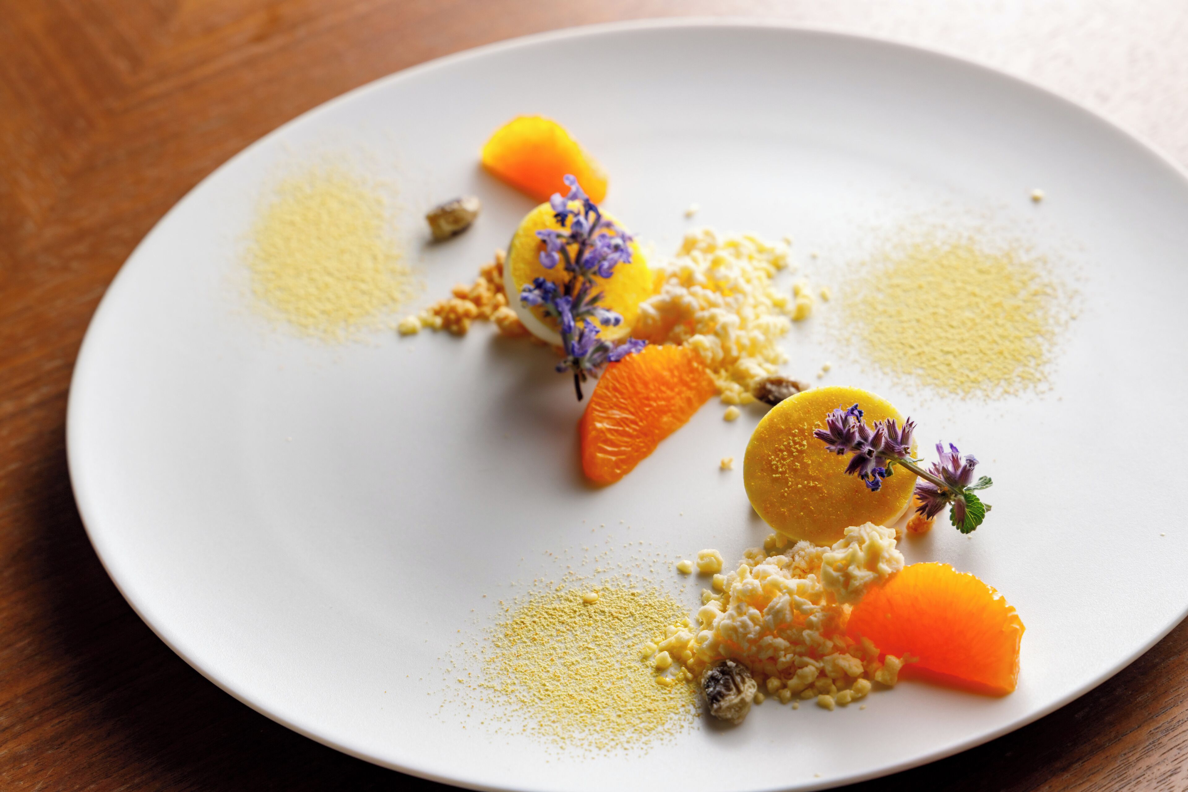 A white plate with food arranged on a wooden table.