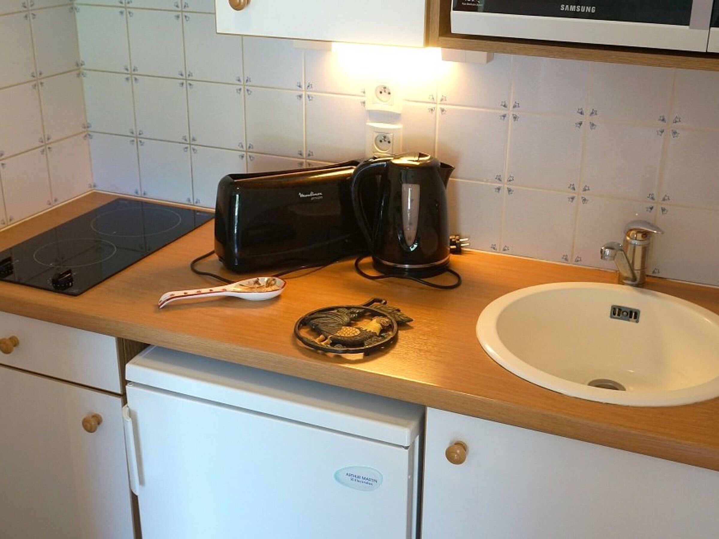 A kitchen with a stove, a coffee maker, a sink, and a microwave.