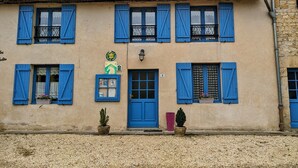 Ein Gebäude mit blauen Fensterläden, einer grünen Schilder und der Hausnummer 9.