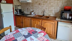 Eine Küche mit Kühlschrank, Herd, Spüle und Mikrowelle.